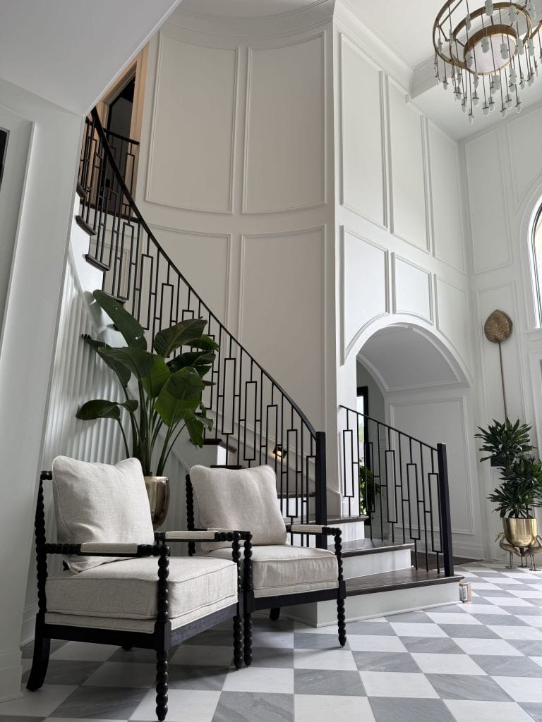 Two-story foyer with white picture-frame wall moulding and a curved staircase
